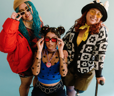 Three of diverse, colourfully dressed people, one is in a wheelchair and another has a walking stick.